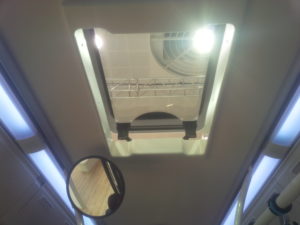 electric escape hatch with single pane glass on a city bus